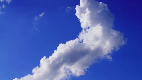 Clear blue sky features fluffy white cumulus clouds on a bright sunny day Stock Footage 325488112