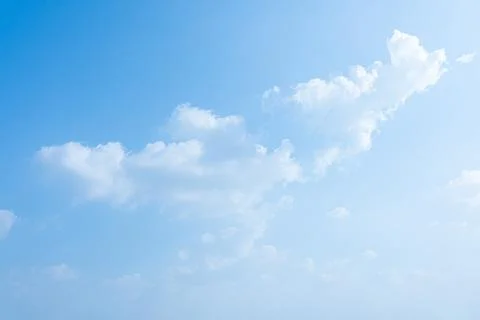 Clear blue sky filled with soft white fluffy clouds during sunny daytime Stock Photos
