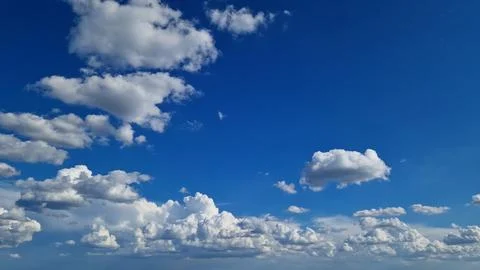 Clear blue sky with fluffy big white clouds on a sunny day Stock Photos