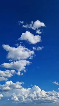 Clear blue sky with fluffy big white clouds on a sunny day Stock Photos