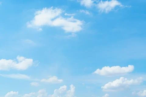 A clear blue sky with fluffy white clouds creates serene and peaceful atmosph Stock Photos
