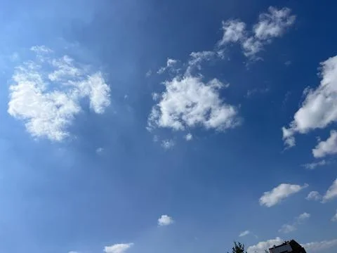 Clear Blue Sky with Fluffy White Clouds Background Stock Photos