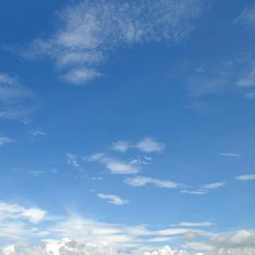 Clear blue sky with light scattered white clouds square frame background wi.. Stock Photos