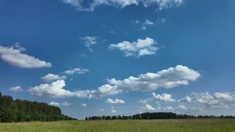 Clear blue sky with puffy clouds over farming land in summer afternoon Stock Footage 315314229