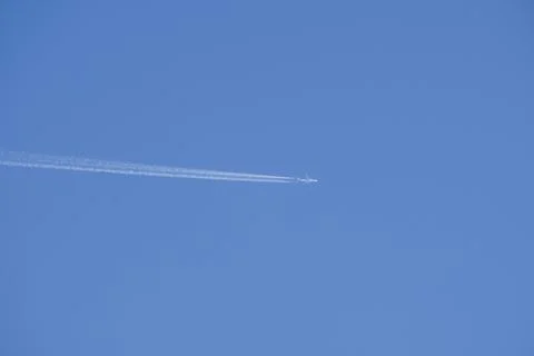 Clear blue sky with random traces of burned fuel from the plane on a clear Su Stock Photos