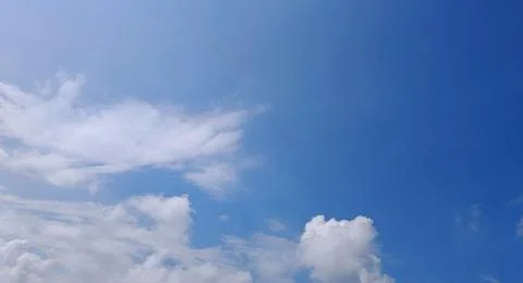 Clear Blue Sky with Scattered Clouds Stock Photos