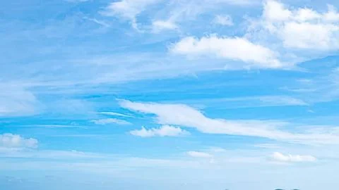 Clear blue sky with scattered white clouds on a sunny day Stock Photos