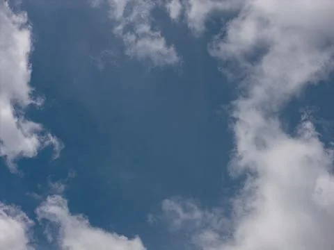 Clear blue sky with small white clouds Фото