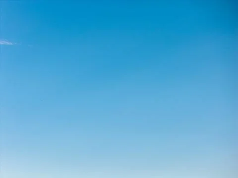 Clear blue sky with a smooth gradient from deep blue to pale near the horizon Stockfoto's