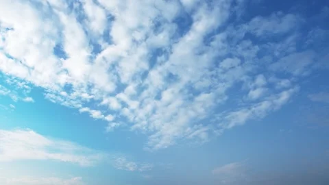 Clear blue sky with soft white clouds drifting slowly on a sunny day Stock Footage 342014298