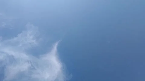 Clear blue sky with soft white wispy clouds drifting across the atmosphere Video stock 343553942