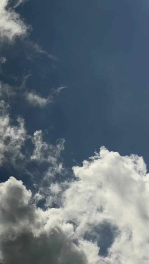 Clear blue sky with white fluffy clouds. Vertical video Stock Footage 277341118