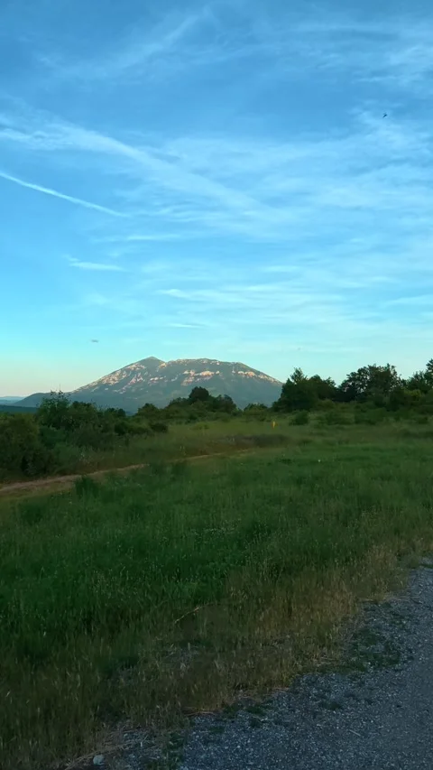 Clear blue sky with wispy clouds above green fields. Mount Rtanj Area. Vertical Stock Footage 340899101