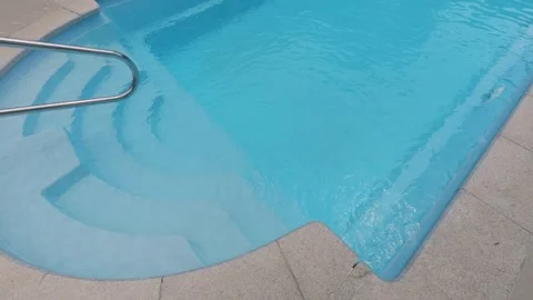 Clear Blue Swimming Pool Entry Steps with Metal Handrail at Resort Stock-Footage 344269181
