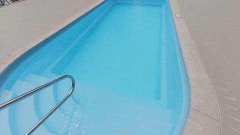 Clear Blue Swimming Pool Entry Steps with Metal Handrail at Resort Vídeos de archivo 344269384