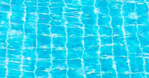 Clear blue swimming pool water with shimmering reflections and tiled pattern Stock Footage 338022347
