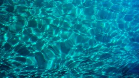 Clear blue turquoise colored ocean sea water ripple background texture. Stock Photos