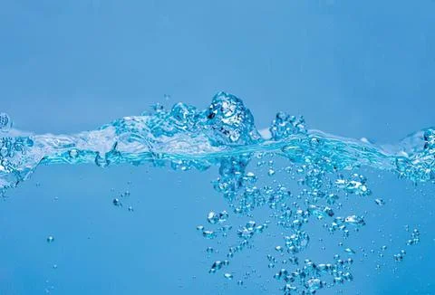Clear blue water with bubbles and splash in a natural setting Stock-Fotos