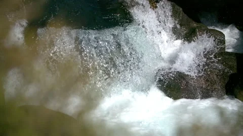 Clear blue water flows through scenic rapids in close-up - Super slow motion Stock Footage 130229115