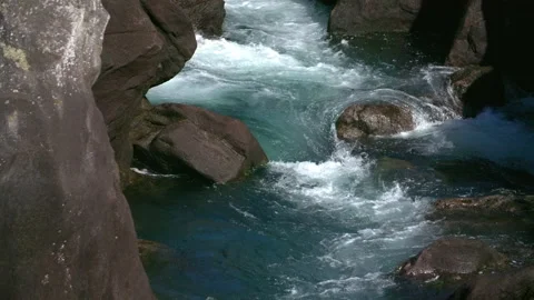 Clear Blue water flows through rocky rapids in scenic NZ river - Slow motion Stock Footage 130231958