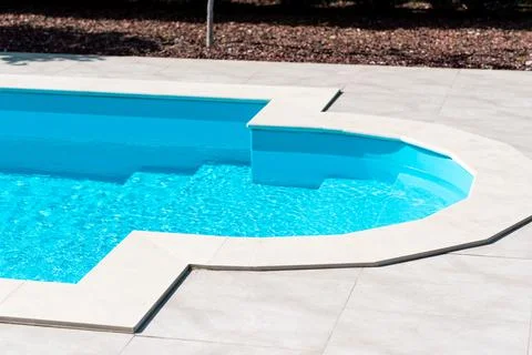 Clear blue water in the pool. Side view. Relax in the backyard of a country h 스톡 사진