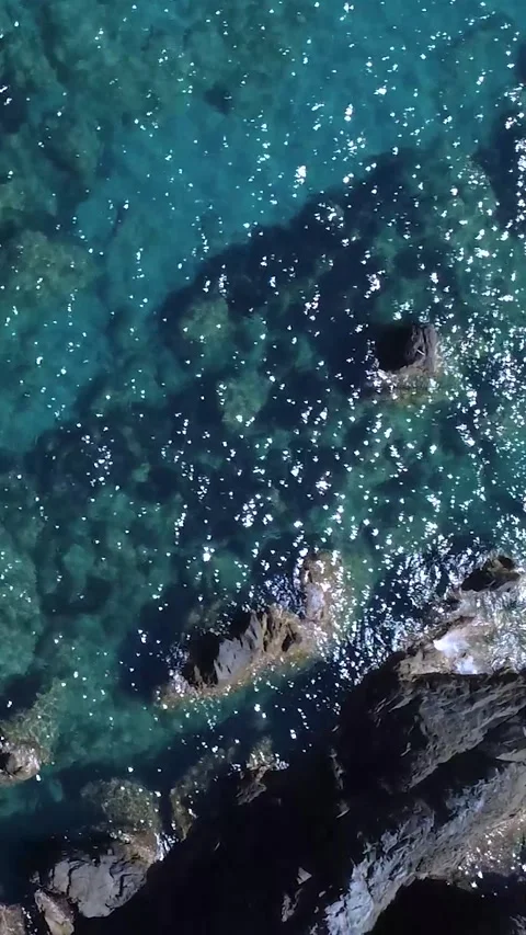 Clear Blue Water Showing Rocks and Waves Under Bright Sunlight at Coastal Area Stock Footage 322936142