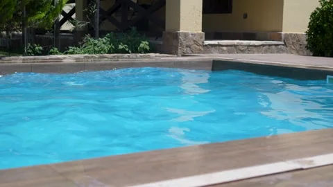 Clear blue water softly rippling in an outdoor swimming pool on a sunny sum.. Stock Footage 341341339