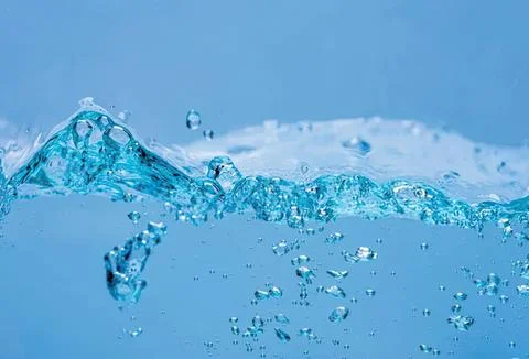 Clear blue water splash with bubbles and droplets Stock-Fotos