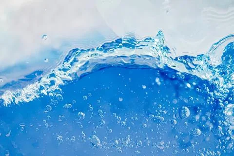 Clear blue water splash with bubbles and waves Stock Photos