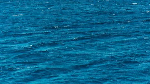 A clear blue water surface captures the deep texture of ripple waves and liquid  스톡 사진
