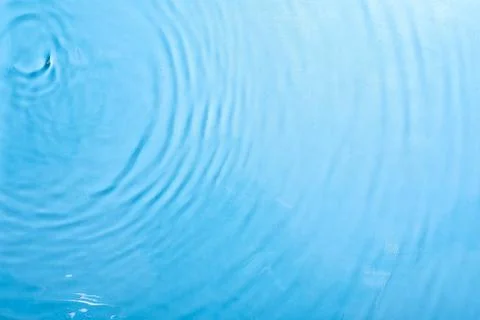 Clear blue water surface with concentric ripples and gentle waves, refreshing Stock Photos