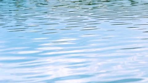 Clear blue water surface with gentle ripples and soft reflections as background Видео 345169799