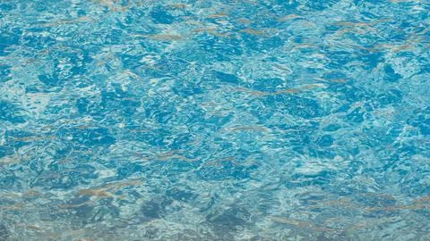 Clear blue water surface texture with ripples and reflections in a swimming pool 스톡 사진