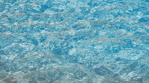 Clear blue water surface texture with ripples and reflections in a swimming pool 스톡 사진