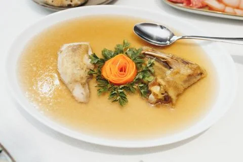 Clear broth holds delicate fish pieces Foto stock