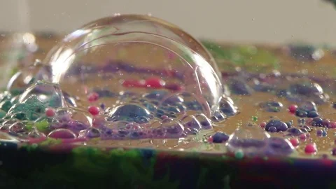 Clear Bubble Pops Among Rainbow Bubbles Stock Footage 75467432