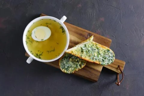 Clear chicken broth with egg served with toasts Foto stock