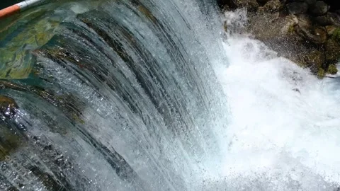 A clear clean water flowing continuously from the waterfall 動画素材 247585233