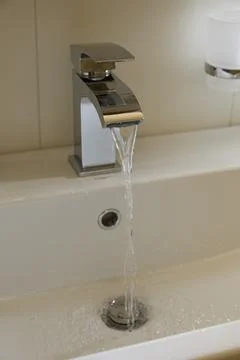 Clear clean water flows from the tap Stock Photos