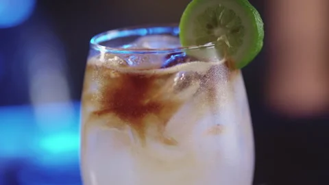 Clear cocktail with bitters and lime slice Video stock 274626233