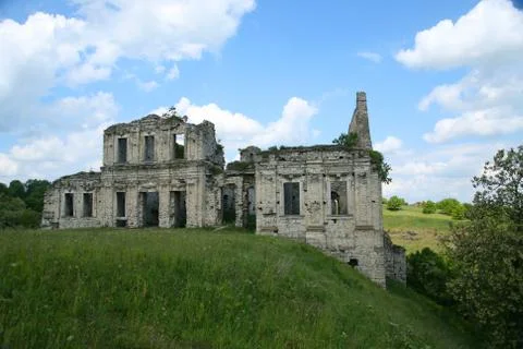 Clear day White clouds An abandoned building made of stone stands in the middle Stock Photos