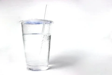 A clear, disposable plastic cup containing water and a plastic straw. Stock Photos