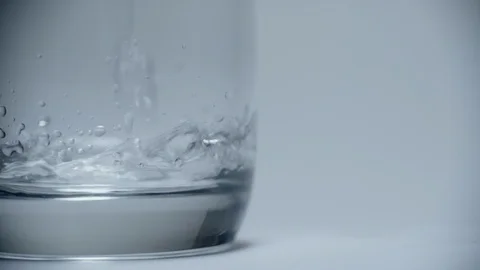 Clear drinking water pours into a clean transparent glass on a white background. Stock Footage 128119918