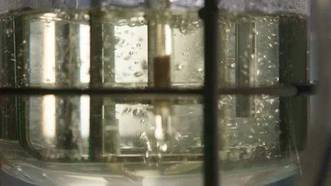 Clear fluid with bubbles is beeing mixed in medical laboratory, pharmacy concept Stock Footage 153475489