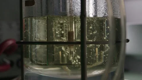 Clear fluid with bubbles is beeing mixed in medical laboratory, pharmacy concept Stock Footage 153475512