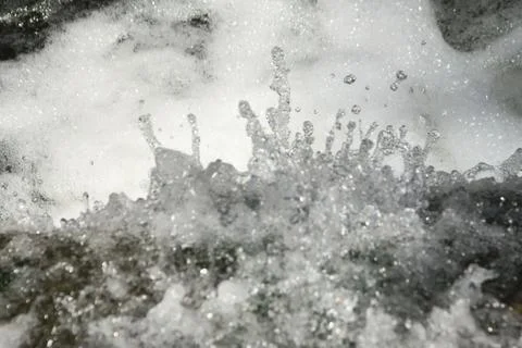 Clear, fresh stream of water splattering in a natural creek. Environmental, w Stock Photos