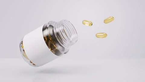 Clear glass jar with blank white label spilling translucent yellow gel caps.. Stock Footage 332150700