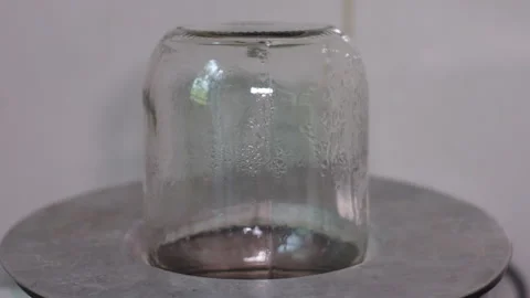 Clear Glass Jar Inverted Over a Heated Metallic Surface in Laboratory Setting Stock Footage 339650056