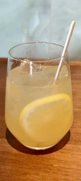 Clear glass of lemonade with ice cubes and lemon slice 库存照片