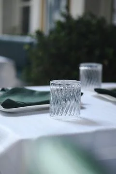 Clear glass on table in dining area with green napkins Foto stock